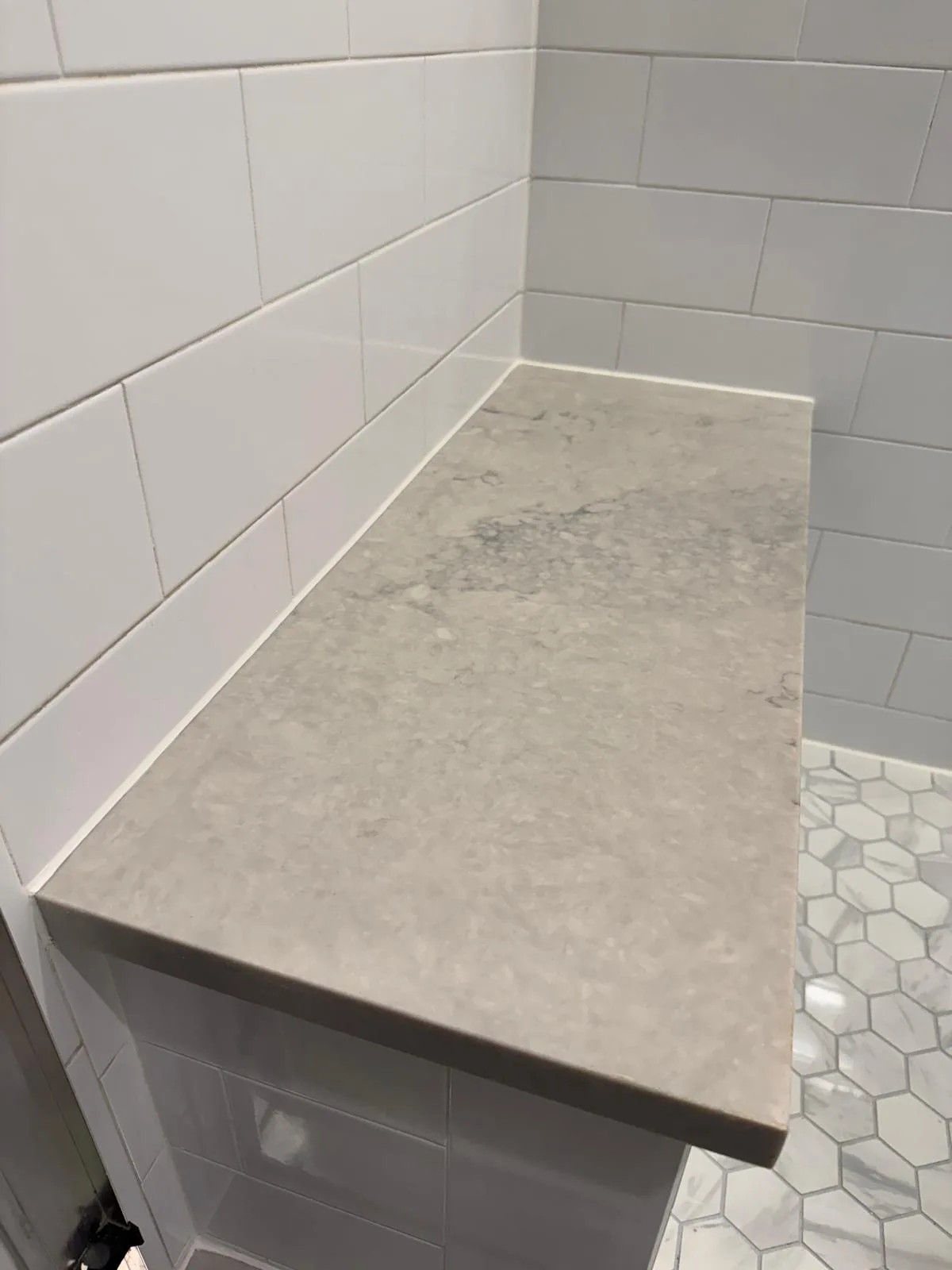 Shower bench with hexagon marble floor tiles
